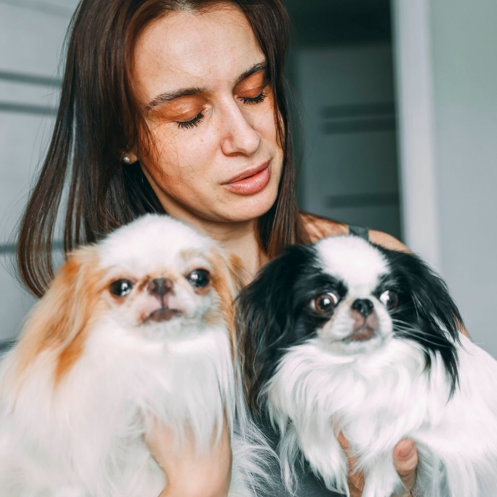 holding two small dogs in her arms